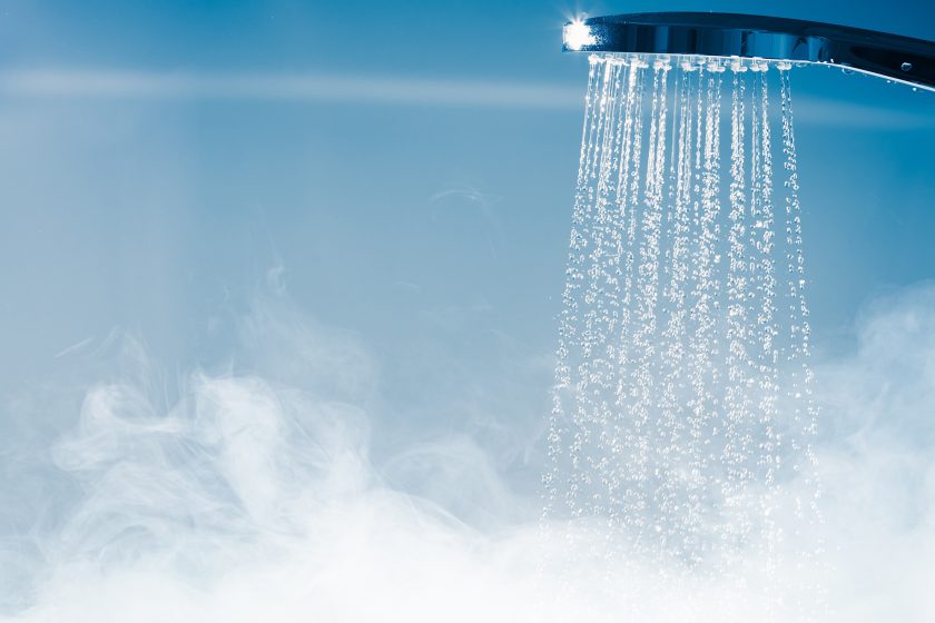 Hot water falling from a shower head, steam rising.